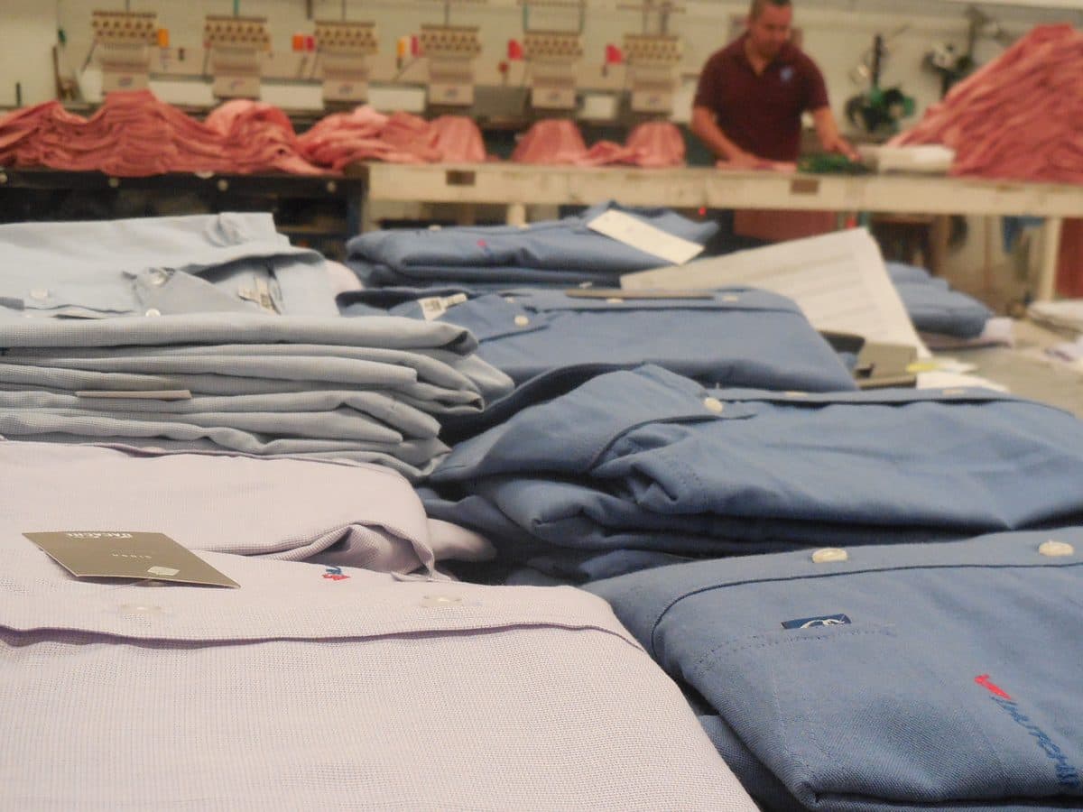 Producción de uniformes en BV Uniformes: bordadora multicabezal y camisas listas para entrega.